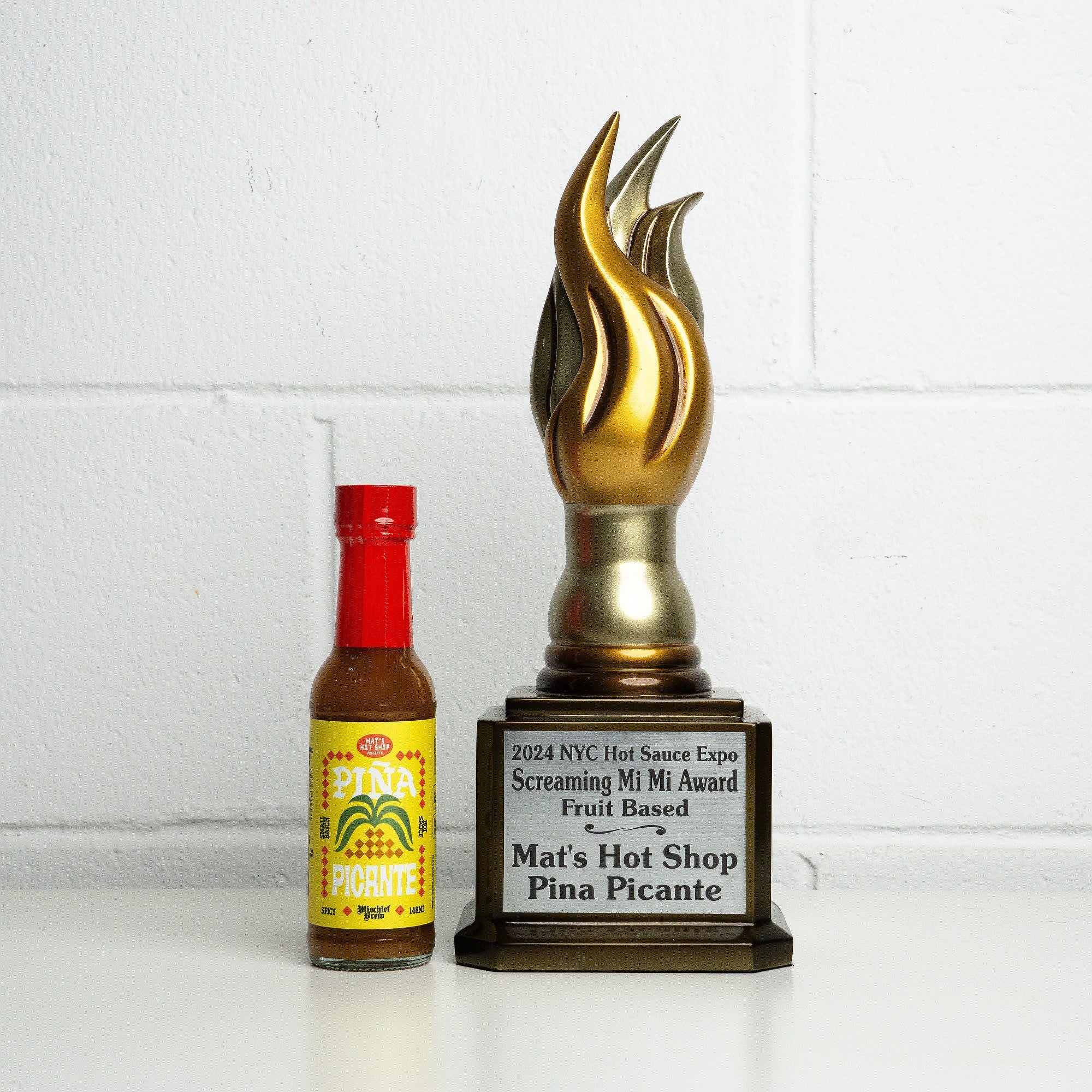 Hot sauce bottle with a trophy on a white background
